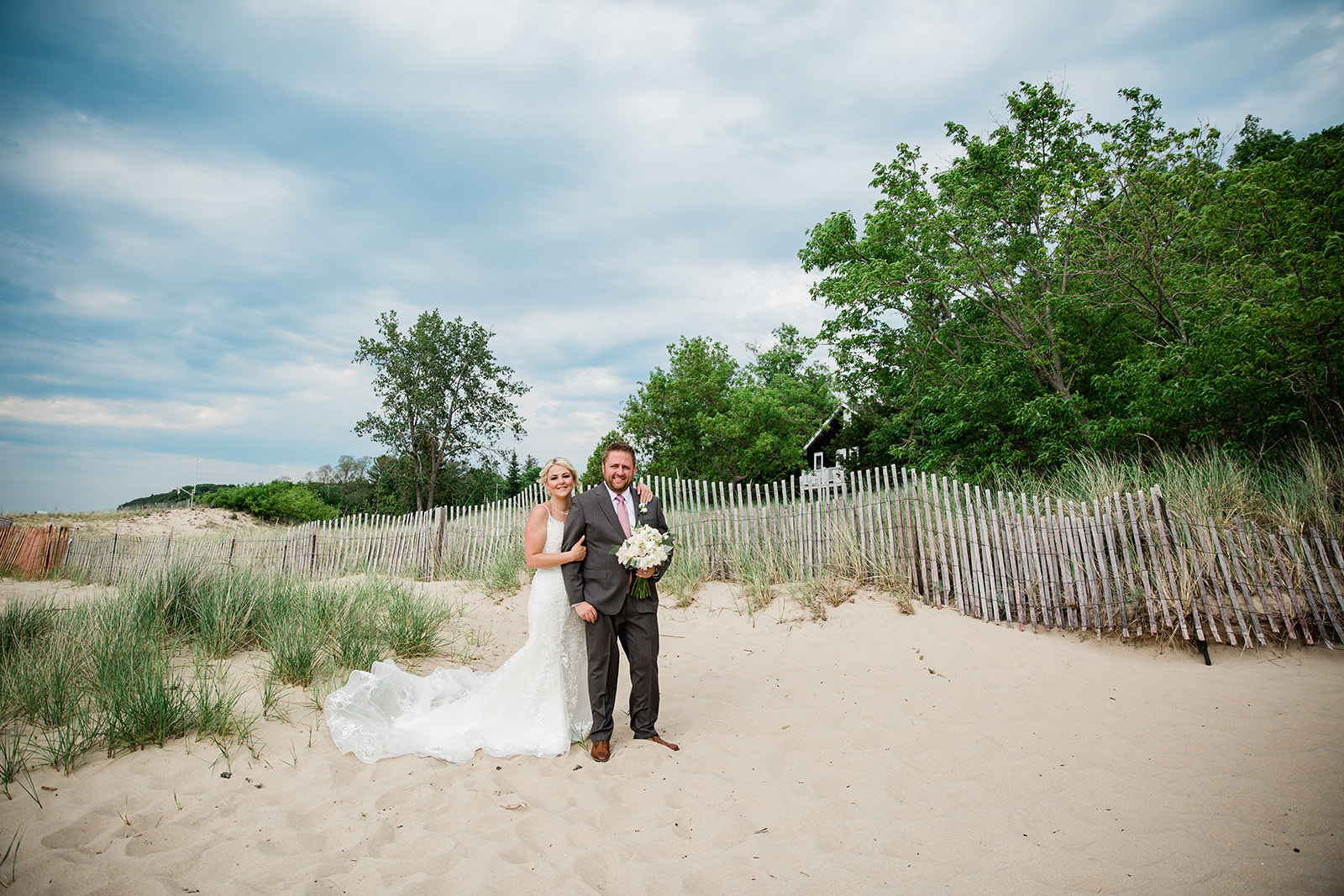 Caitlin + Mike standing on the Shores of Lake Michigan near Fishtown | Heirlooms and Lace Studios