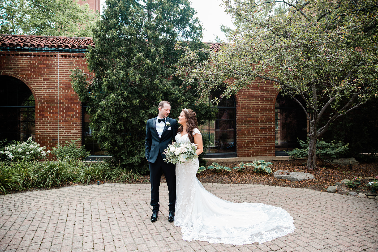 a bride and groom stand in the courtyard at the Saint Johns Resort in Northville Michigan.